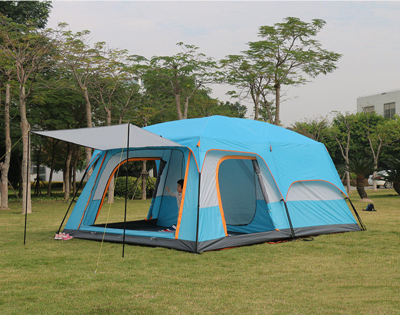 Blue camping tent with gray and orange accents set up in a park.