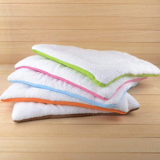 Stack of folded towels with colorful edges on a wooden surface