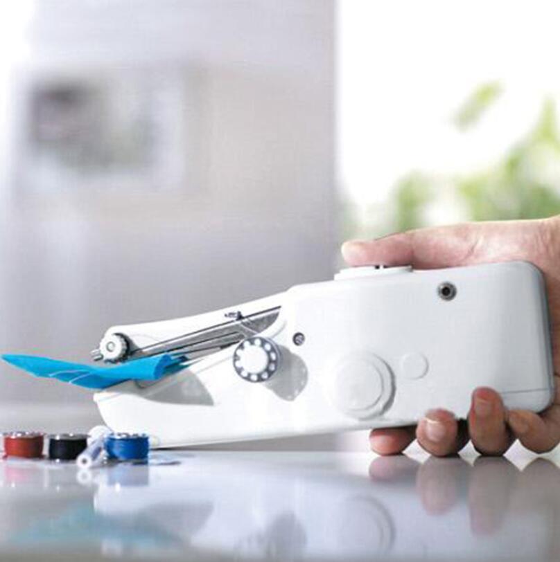 Hand holding a small white sewing machine on a reflective surface with a blurred background