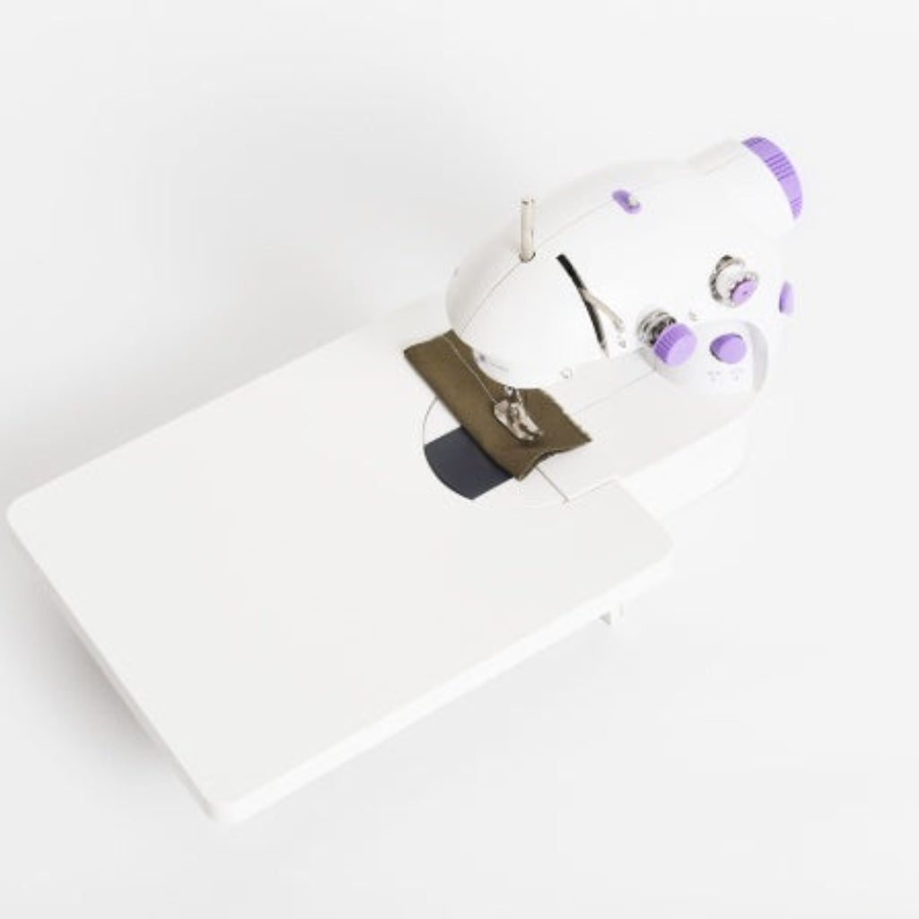White sewing machine with purple accents on a white background