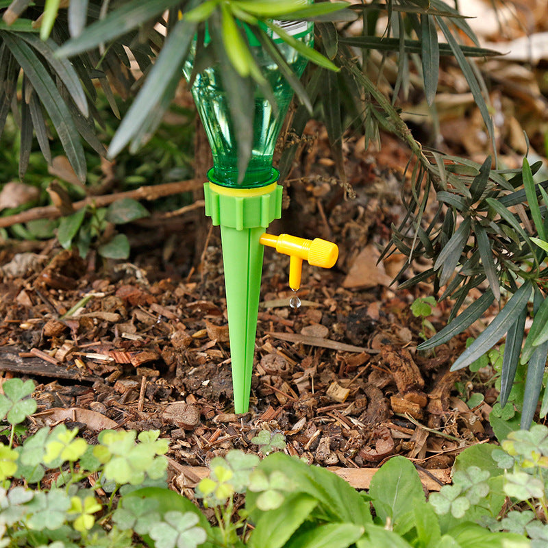 Green and yellow garden watering device in a garden setting