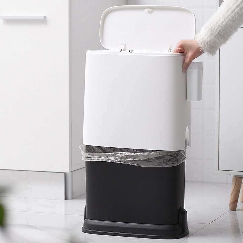 White and black trash bin with a person opening the lid in a kitchen setting.