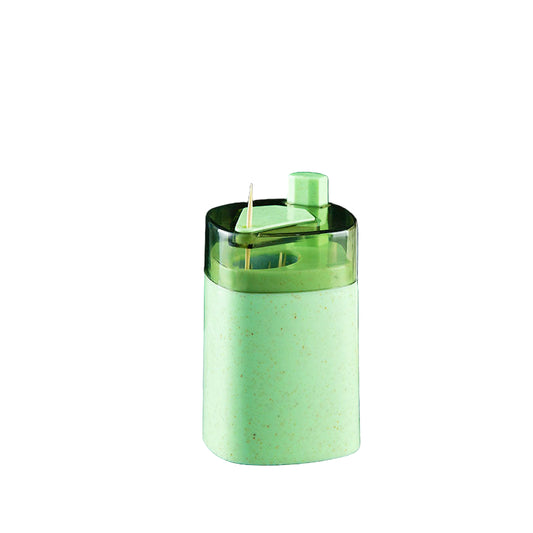 Green kitchen tool with measurements on a gray surface with coffee beans and a white container.