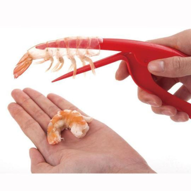 Red shrimp peeler tool being used to remove shrimp from a shell.