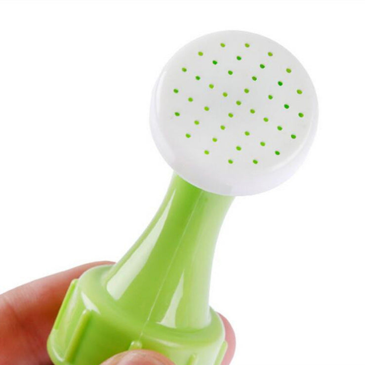 Green and white kitchen tool held by a hand on a white background