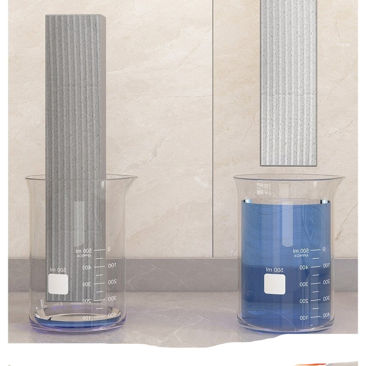 Two beakers with one absorbing water, showing a before and after effect on a tiled wall background.
