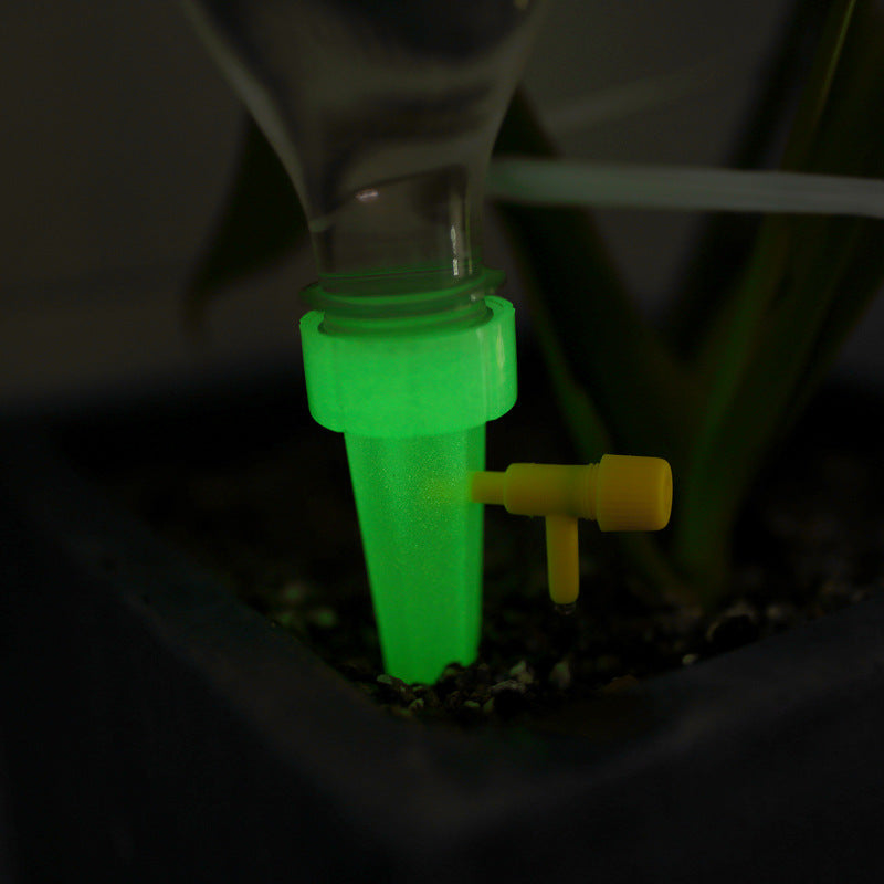 Green glow-in-the-dark tube with a yellow valve on a dark background