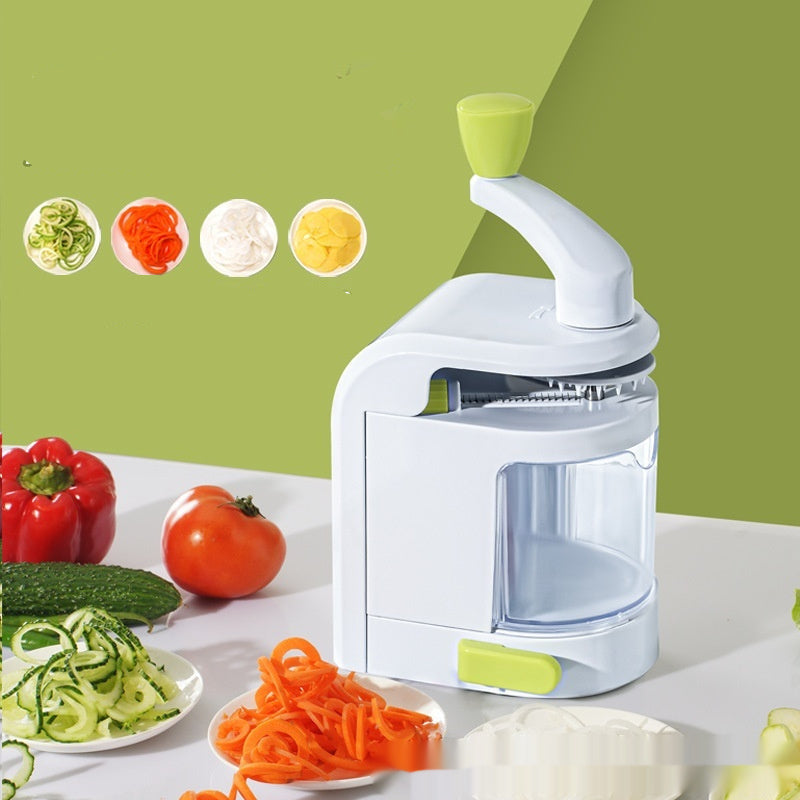 Hand winder with vegetables and spiralized food on a white surface against a green background