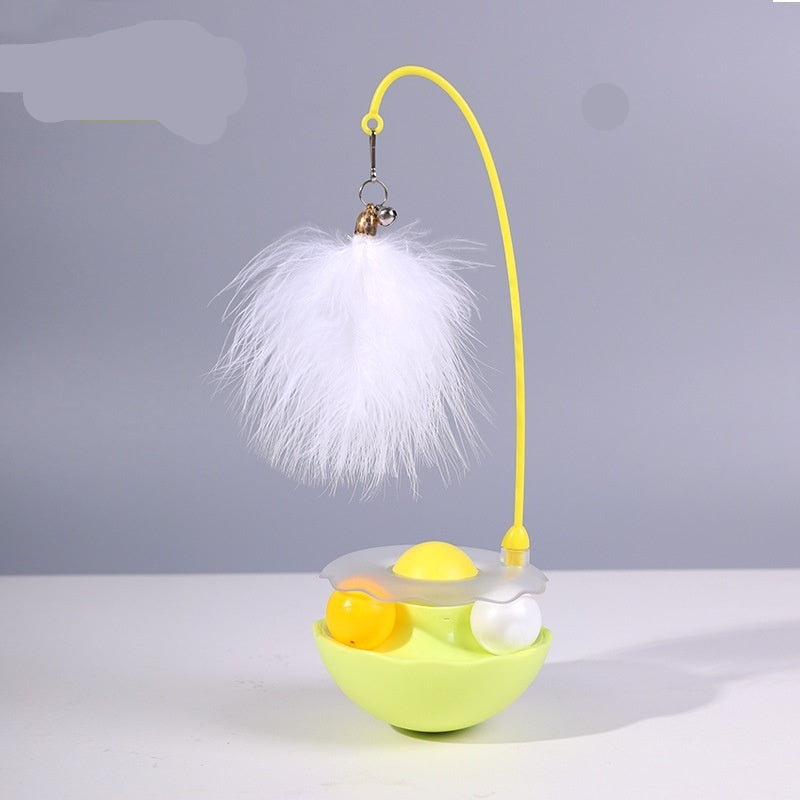 Cat toy with yellow base, white feather, and colorful balls on a gray background
