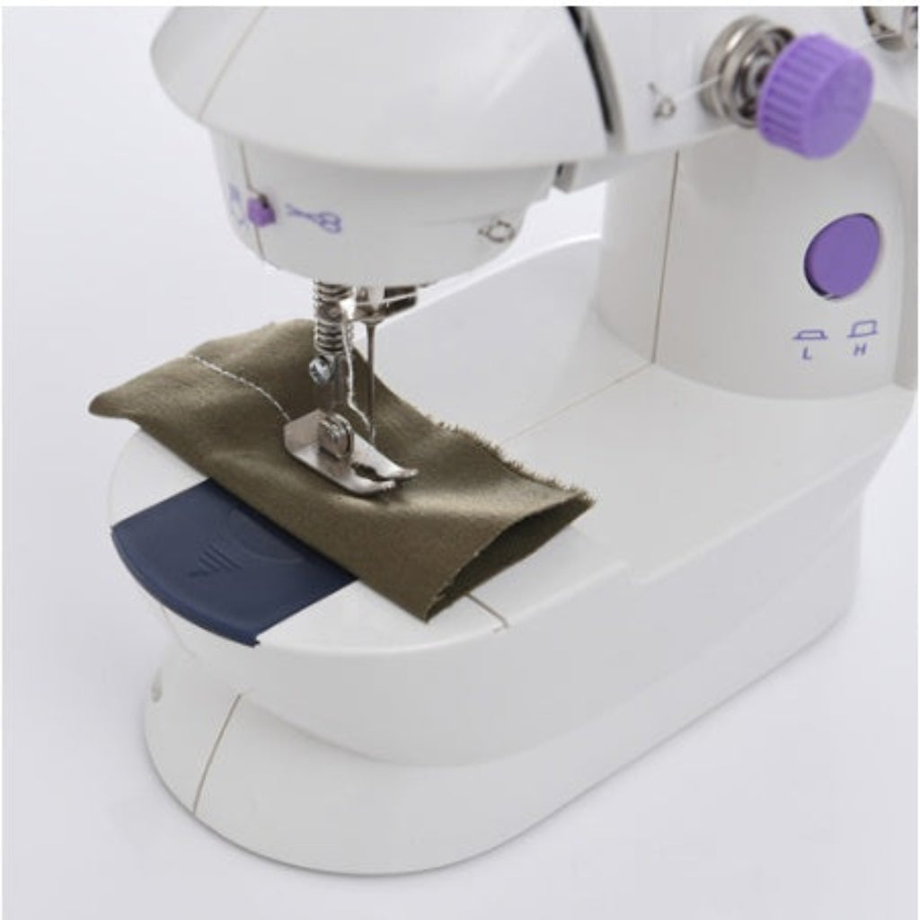 Sewing machine with a piece of fabric on a white background