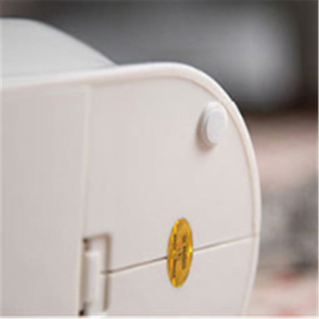 Close-up of a white appliance with a yellow label on a blurred background