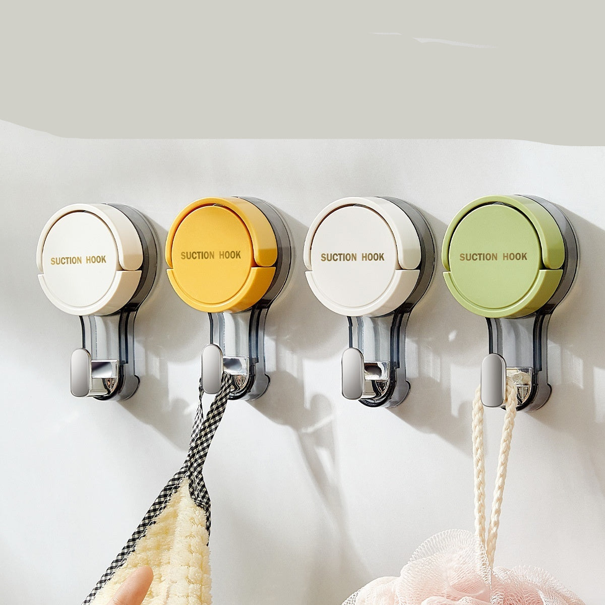 Four suction cup hooks in different colors on a white wall with text describing their features.