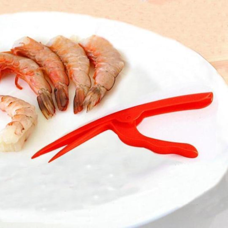 Red shrimp peeler on a white plate with raw shrimp