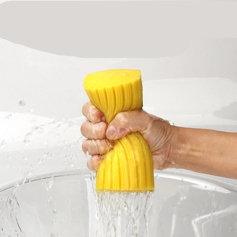 Yellow sponge with water being squeezed out, held over a sink.