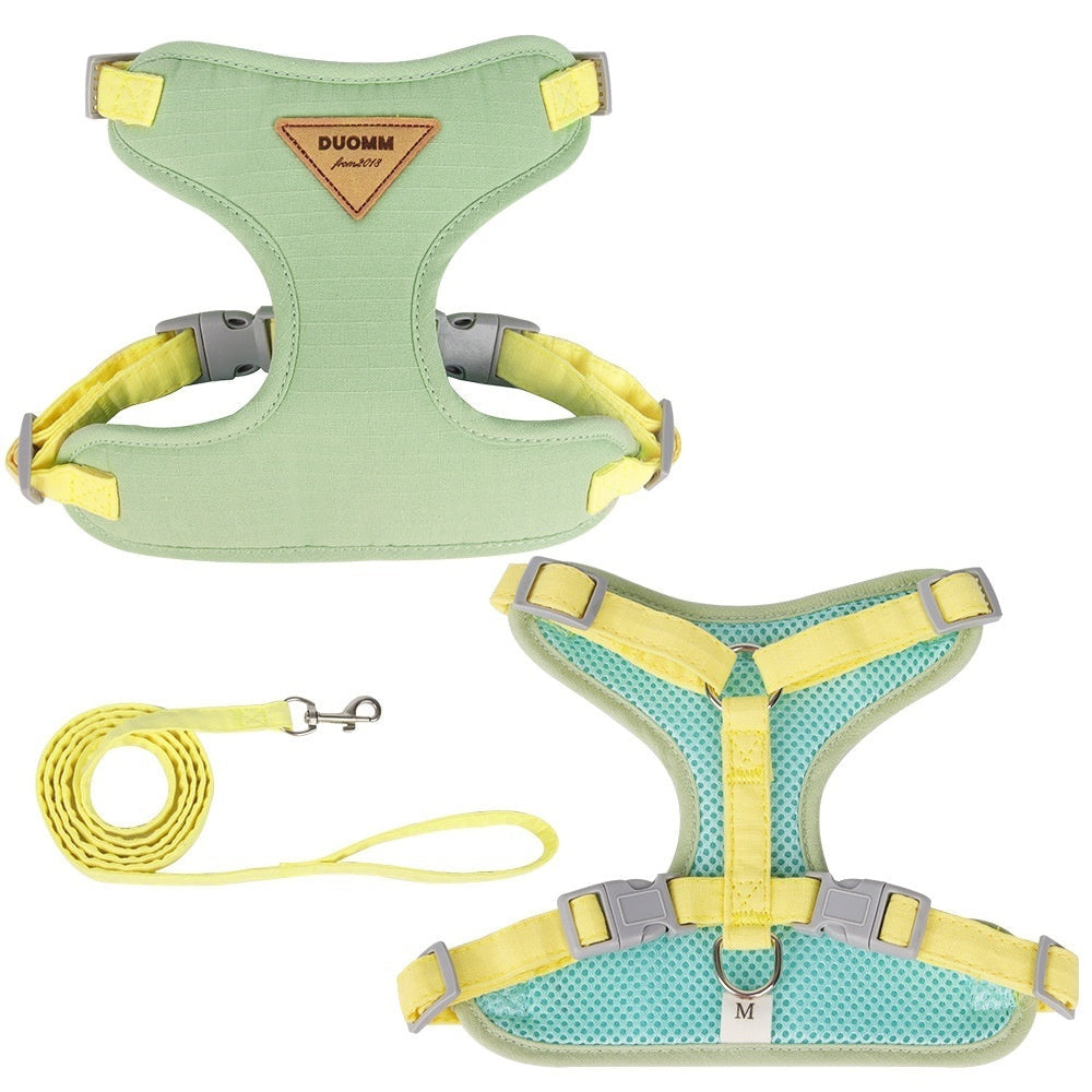 Green and yellow dog harness with matching leash on a white background