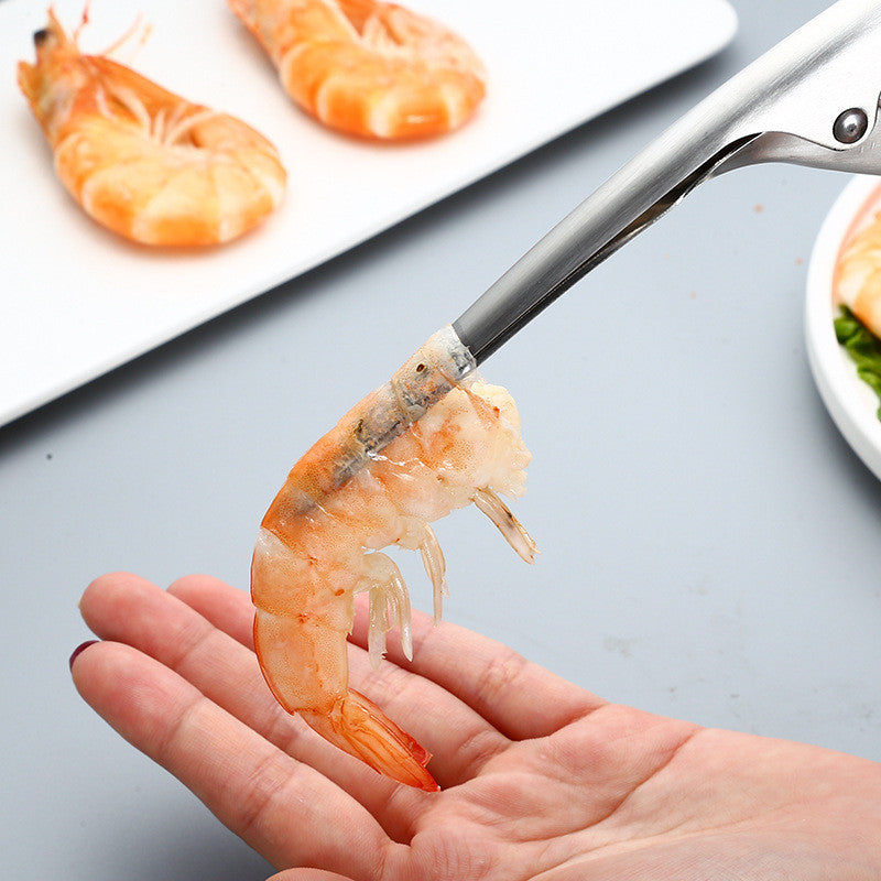 Shrimp being held with tongs on a gray surface with additional shrimp in the background.