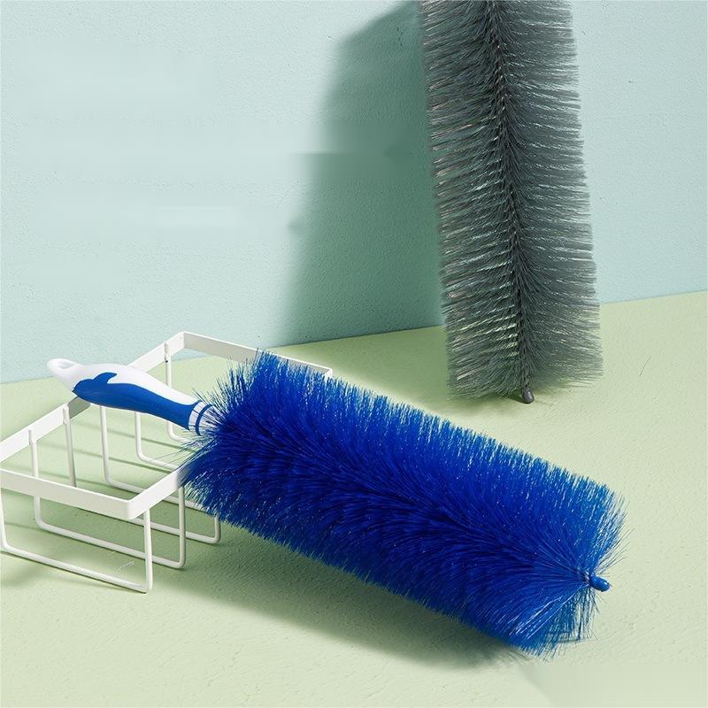 Blue cleaning brush with a white handle on a light green surface.