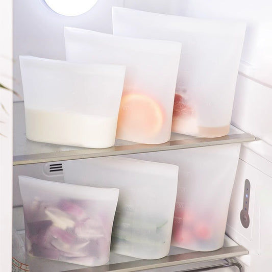 Clear plastic bags with food inside on a refrigerator shelf