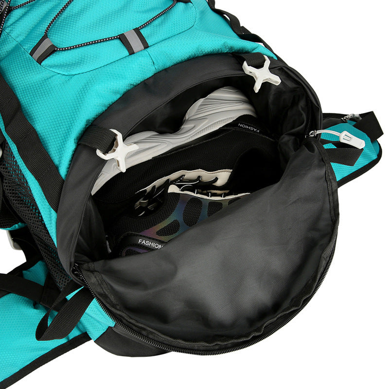 Open teal backpack with black interior showing a white shirt and black pants.