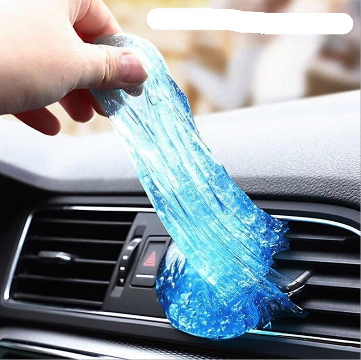 Blue slime being stretched over a car's air vent with text 'Clean every corner'.