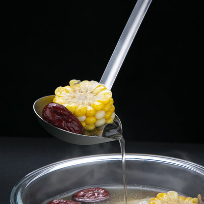Corn on a spoon being dipped into a pot of soup with a black background