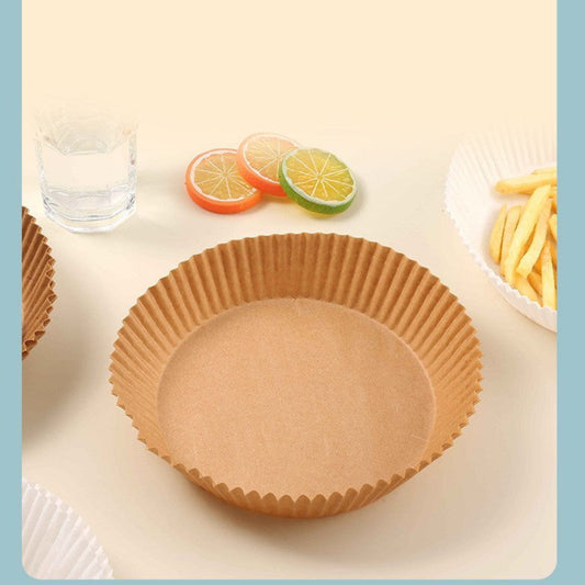 Brown paper cupcake liner on a white surface with fruit slices and a glass of water in the background.
