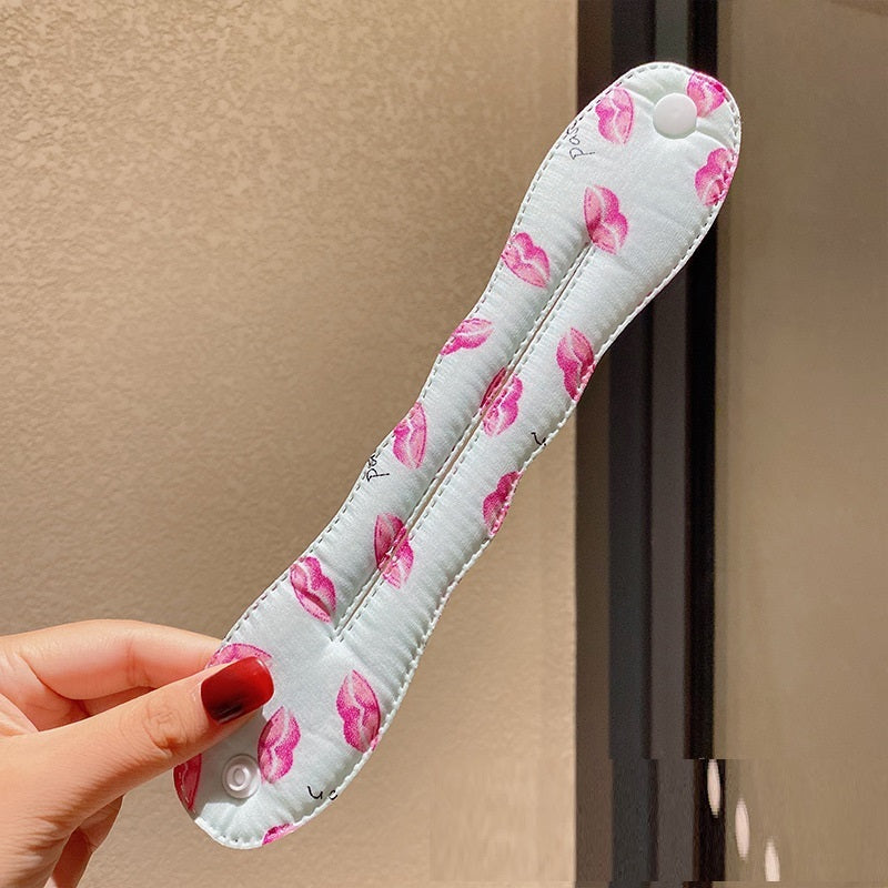 Floral-patterned door handle cover held by a hand against a neutral background