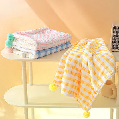 Colorful baby blankets on a small table with a yellow background