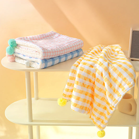 Colorful baby blankets on a small table with a yellow background