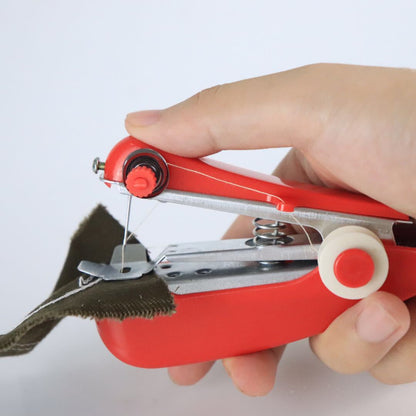 Hand holding a red portable sewing machine on a white background