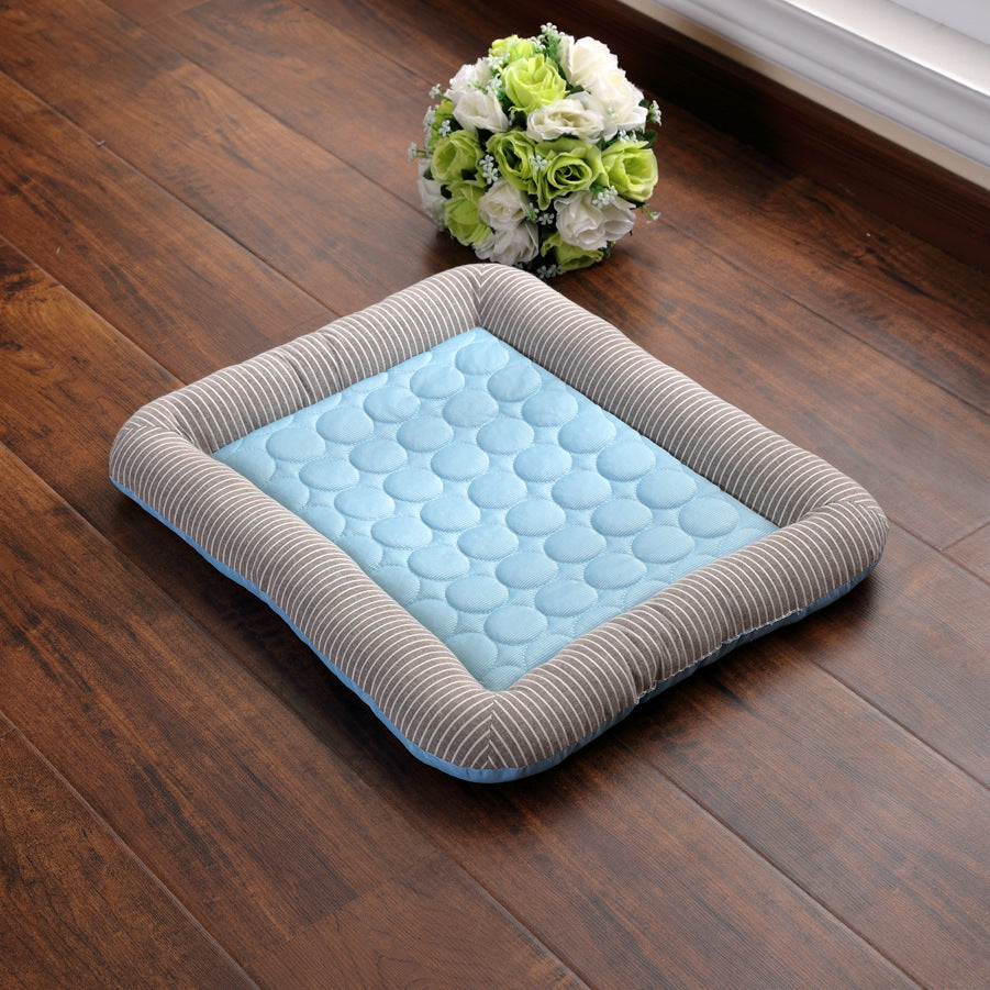 Pet bed with blue cushion on a wooden floor, flowers in the background