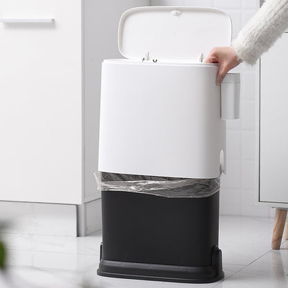 White and black trash bin with a person opening the lid in a kitchen setting.