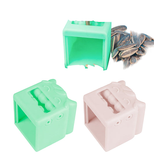 Melon seed sheller with green and pink colors surrounded by sunflower seeds on a light blue background.