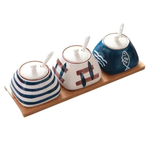 Set of four ceramic condiment bottles with wooden tray on a white background