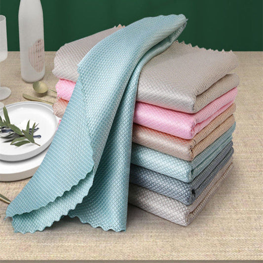 Stack of folded cloths in various colors on a table with a green background