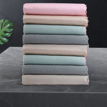 Stack of folded towels in various colors on a dark surface with a leaf decoration.