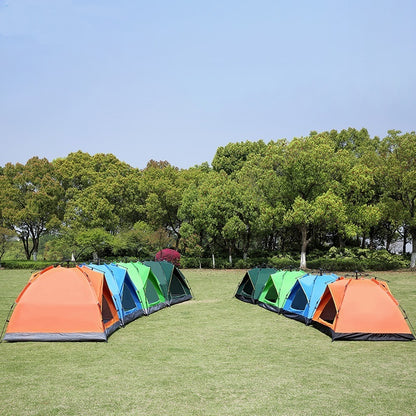 Colorful tents set up on a grassy field with trees in the background