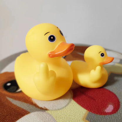 Two yellow rubber ducks on a textured surface with a neutral background