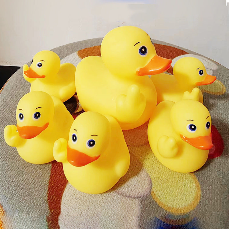 Six yellow rubber ducks on a textured surface