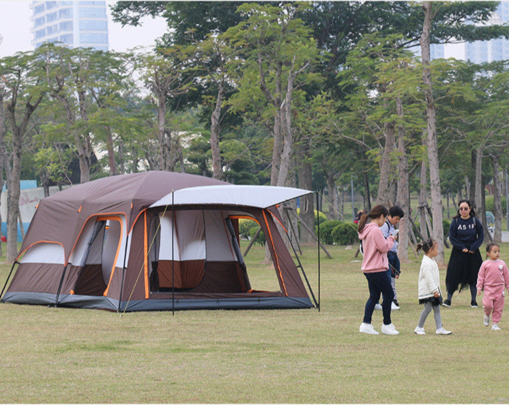 Family with children near a large camping tent in a park setting