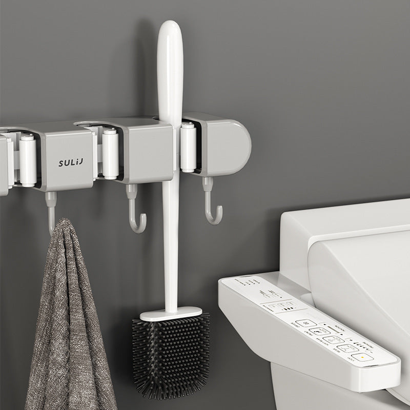 Wall-mounted hook with towel and brush next to a toilet with control panel