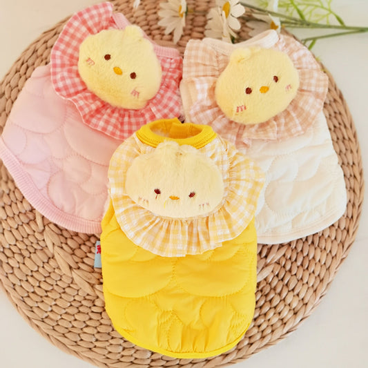 Four baby bibs with cartoon chicken designs on a woven mat.