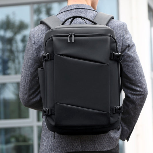 Person wearing a black backpack outdoors with blurred background