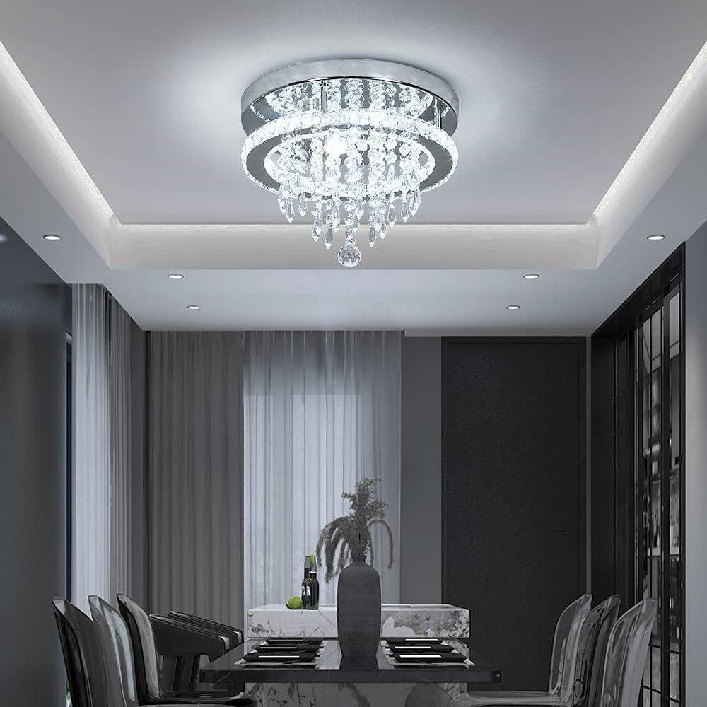 Modern chandelier in a dining room setting with a table and chairs.