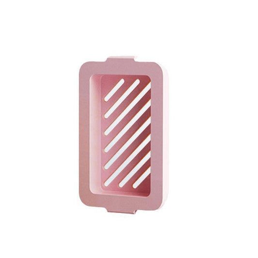 Pink silicone soap dish with white drainage grooves on a white background