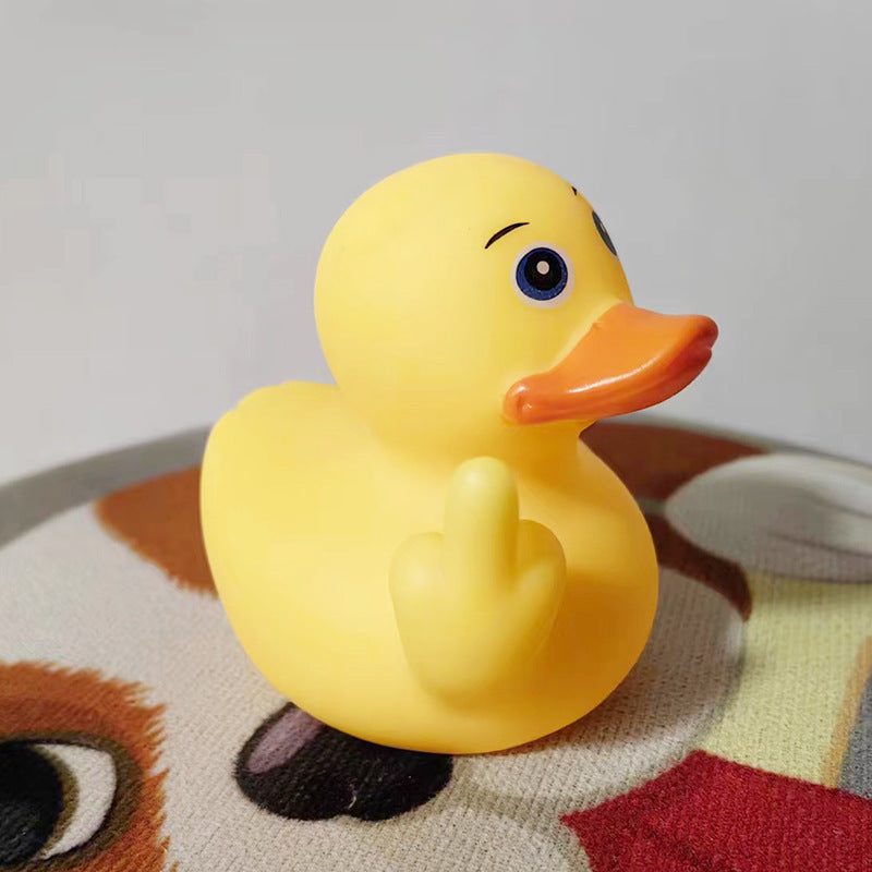 Yellow rubber duck with a blue eye and orange beak on a patterned surface