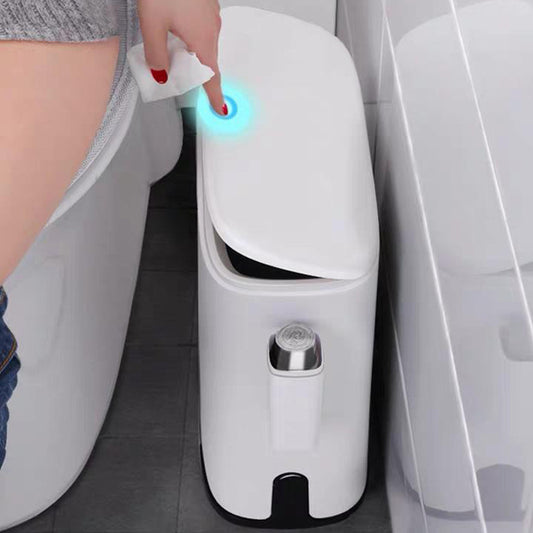 Hand using a white electronic device with a blue light next to a toilet.