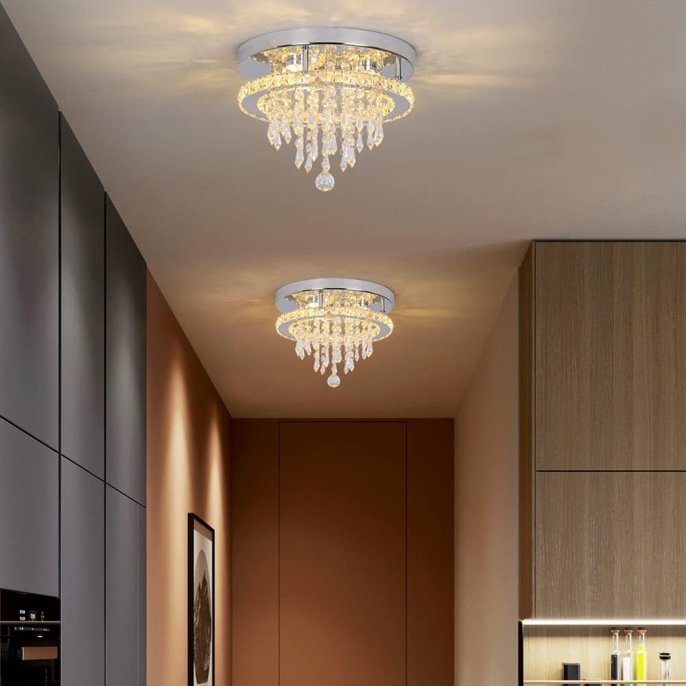 Two crystal chandeliers hanging from a ceiling in a modern interior setting.