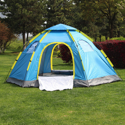Blue and yellow tent set up on grass with trees in the background