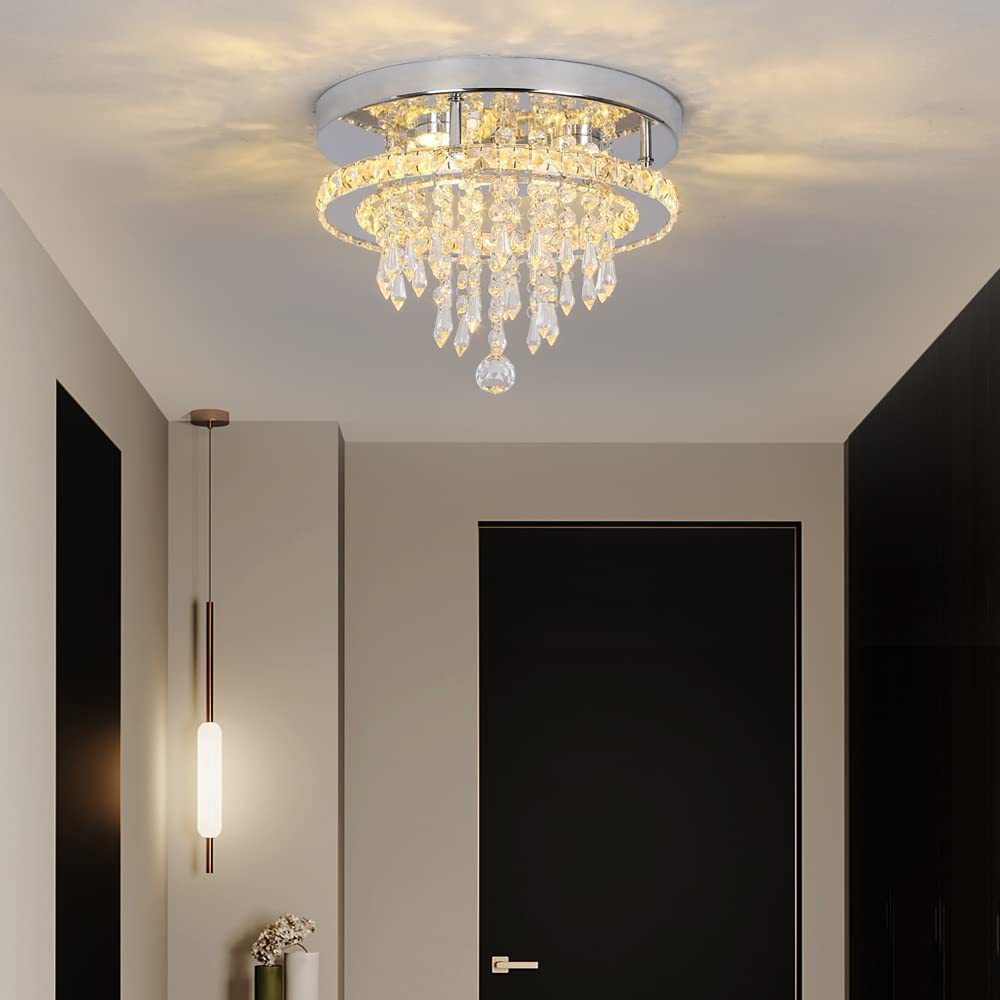 Chandelier hanging in a room with a door and wall light fixture.